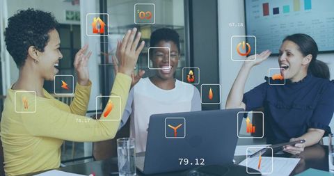 High-fiving colleagues celebrating data-driven win during collaborative meeting in modern office