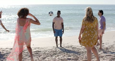 Diverse Friends Enjoying Volleyball Game on Sunny Beach Day