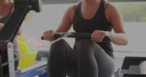 Woman using rowing machine for fitness training in gym