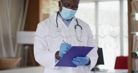 Doctor Reviewing Patient Notes in Clinic While Wearing Mask and Gloves