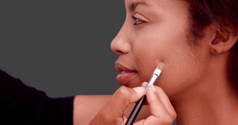 Makeup artist applying foundation to model's face