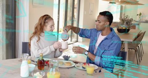 Couple sharing cozy breakfast pouring coffee at sunlit modern open-plan kitchen table