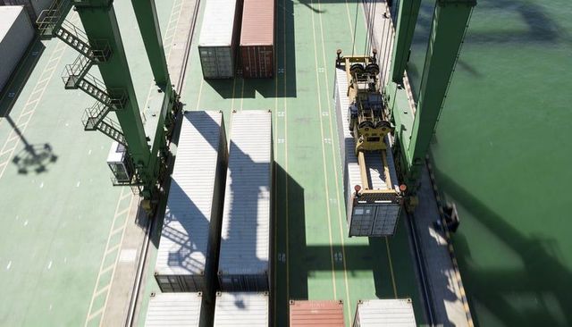 Overhead crane lifting shipping container at busy port terminal with green gantry cranes
