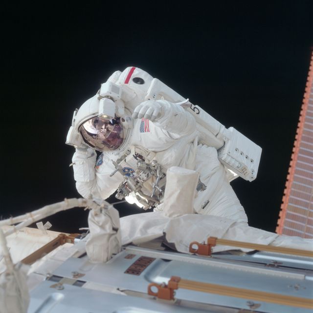 Image displays an astronaut performing maintenance during an extravehicular activity (EVA) in zero gravity. Ideal for topics related to space exploration, space missions, NASA, advanced technology, and science education. Perfect for educational content, articles on space missions and technology, and visual representations of space exploration.