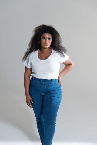 African american model wearing white ribbed tee and blue jeans, confident studio portrait