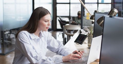 Focused Businesswoman Typing at Modern Shared Workspace - Download Free Stock Images Pikwizard.com
