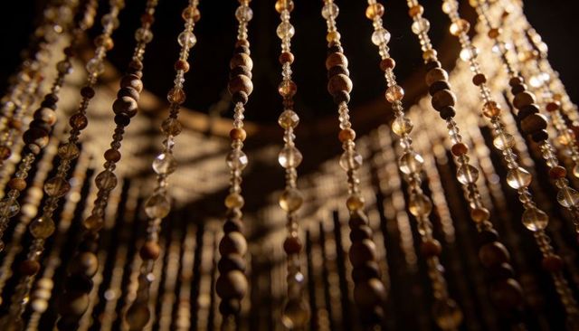 Glowing amber bead strands catching warm light, faceted glass and wooden beads chandelier