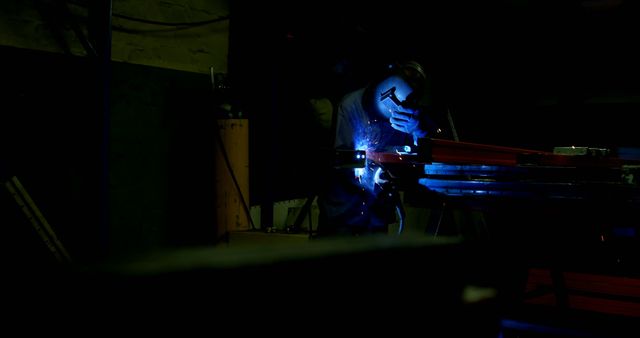 Welding Worker Illuminated by Bright Spark in a Dark Industrial Factory - Download Free Stock Photos Pikwizard.com