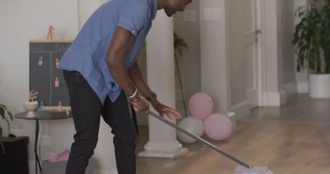 Man Cleaning Floor for Baby Shower with Pink Decorations