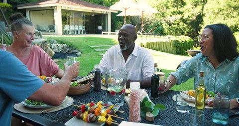 Diverse Friends Enjoying Outdoor Dining in Relaxed Backyard Setting