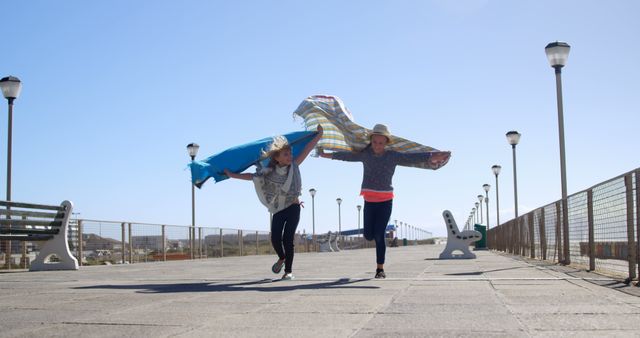 Children running joyfully on a pier with towels - Download Free Stock Images Pikwizard.com