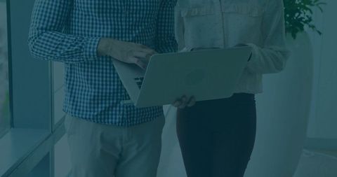 Business Colleagues Collaborating with Laptop in Modern Office Environment