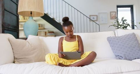 Young girl enjoying digital tablet in comfortable home environment