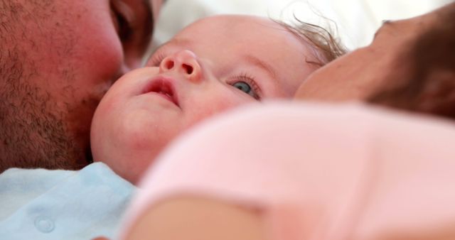 Loving Parents Kissing Baby's Cheeks in Tender Moment - Download Free Stock Images Pikwizard.com