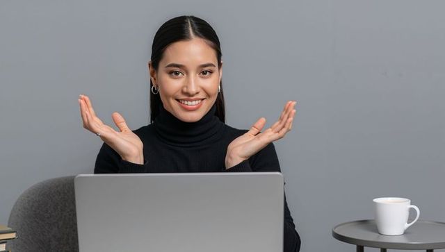 Confident Asian Businesswoman Working Online with Laptop in Minimalist Office
