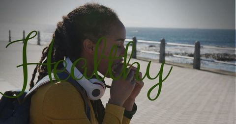 Woman Enjoying Snack on Coastal Promenade