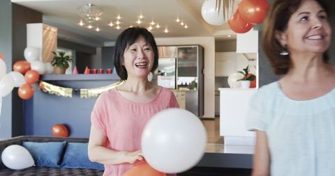 Senior Female Friends Decorating for Birthday Celebration