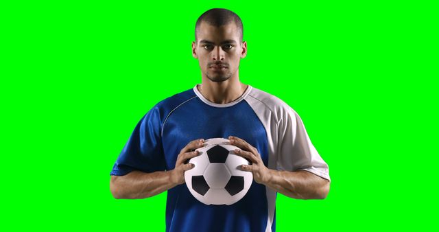 This image features a male soccer player wearing a blue and white jersey, holding a soccer ball, silhouetted against a green screen background. Ideal for use in sports promotions, athletic endorsements, advertisement campaigns, and design projects needing a customizable background. Useful for creating sports-themed educational materials and social media content.