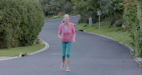 Senior Woman Jogging on Suburban Street Holding Water Bottle - Download Free Stock Images Pikwizard.com