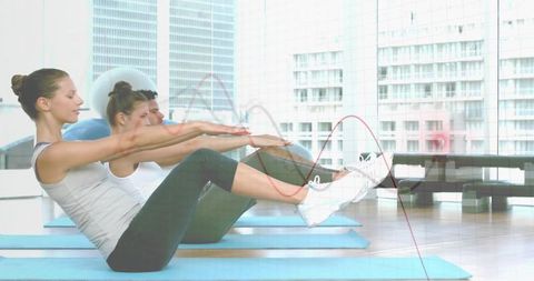 Group pilates workout with v-sit exercise in bright studio