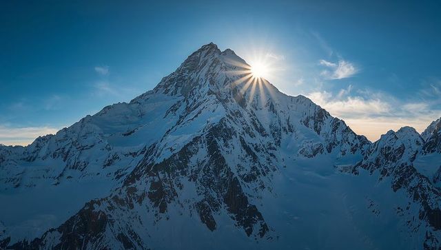 Sunburst over Snow-Capped Alpine Peak at Sunrise, Dramatic Glacier Ridge Panorama