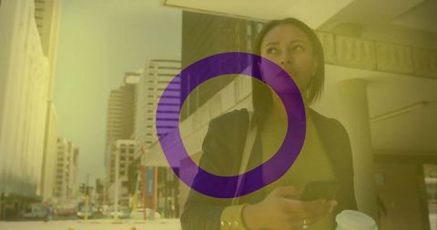 Businesswoman multitasking with smartphone and coffee downtown