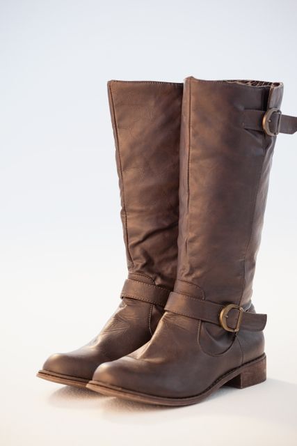 Brown leather wellington boots with buckles, perfect for showcasing fashion accessories, autumn and winter footwear collections, or casual style. Ideal for use in fashion blogs, online shoe stores, and promotional materials for clothing brands.