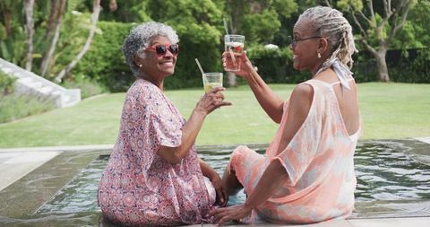 Joyful African American Senior Women Toasting Poolside in Summer