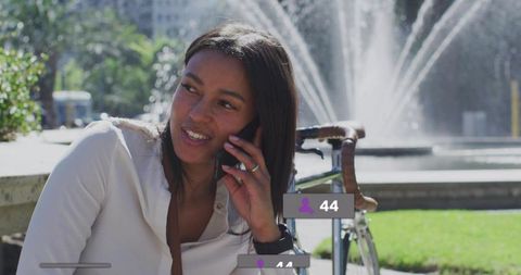 Smiling Woman Talking on Phone with Urban Fountain Background