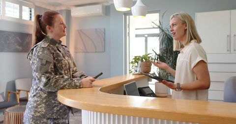 Military servicemember consulting at front desk in modern office