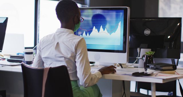 Businesswoman Analyzing Financial Graphs on Desktop Computer in Modern Office - Download Free Stock Images Pikwizard.com