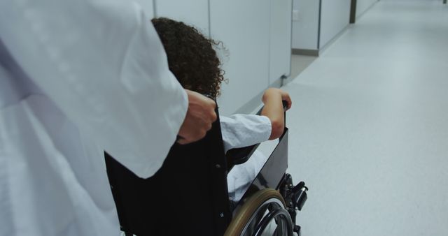 Doctor Assisting Child in Wheelchair through Hospital Corridor - Download Free Stock Images Pikwizard.com