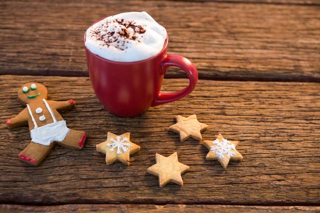 Perfect for holiday-themed promotions, Christmas greeting cards, festive blog posts, and social media content. Captures the cozy and warm atmosphere of the holiday season with a hot drink and festive treats.