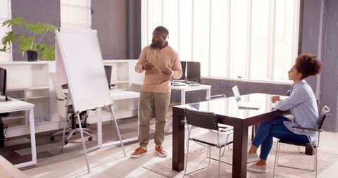 Businessman Presenting on Whiteboard in Modern Office Setting