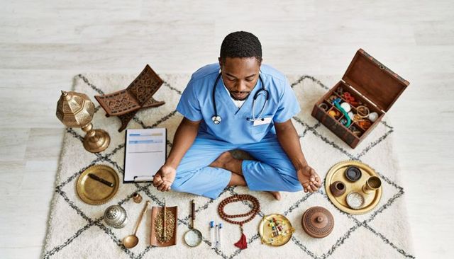 Male nurse meditating in scrubs with ritual objects for clinician wellness