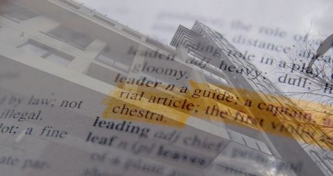 Double exposure city high-rise tilting with dictionary text highlighted by yellow marker