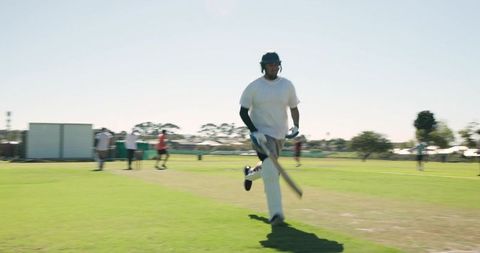 Asian indian batsman sprinting between wickets during suburban cricket match, motion