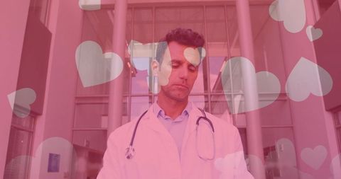 Caring Doctor Standing in Hospital Lobby with Heart Overlay