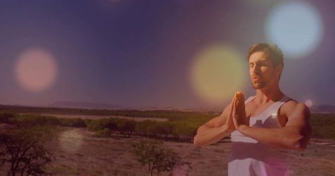 Mindful Man Meditating on Sunlit Grassy Landscape