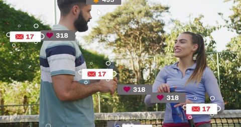 Young couple chatting on tennis court with social media notifications and sports gear
