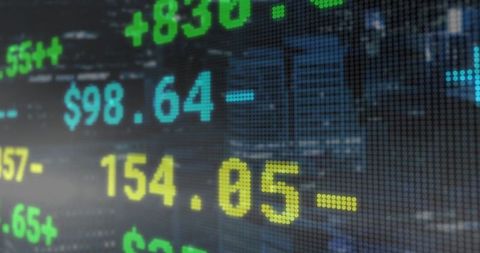 Digital stock market ticker display with cityscape background