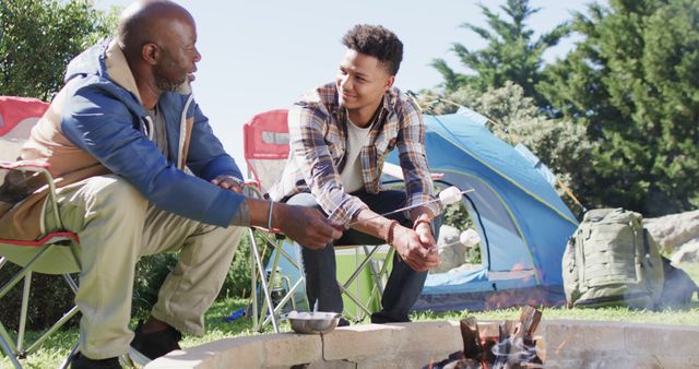 Father and Son Bond Over Campfire Toasting Marshmallows Outdoors - Download Free Stock Images Pikwizard.com