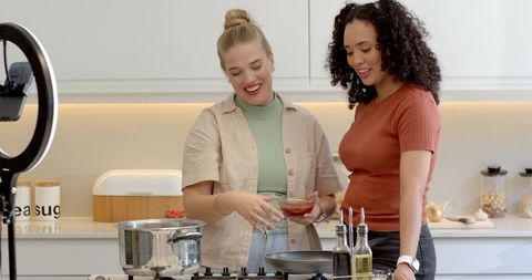 Friends creating cooking content together in modern kitchen