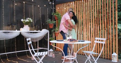 Romantic Evening Embrace on Cozy Outdoor Patio Setting