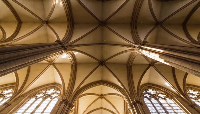 Gothic ribbed vaults and clustered columns showcasing ornate bosses in cathedral ceiling