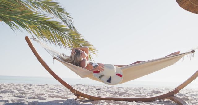 Happy caucasian woman lying in hammock on beach. Lifestyle, realxation, nature, free time and vacation.