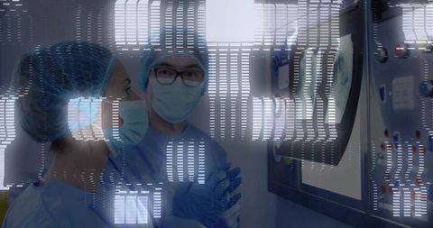 Surgeons analyzing data on wall monitor in sterile operating room