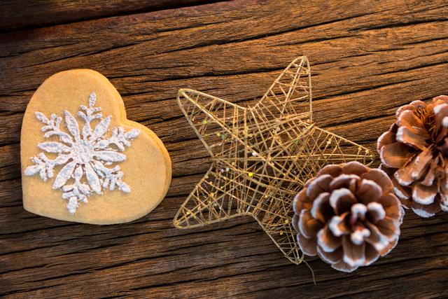 Heart shape cookies, pine cone and star on wooden plank during christmas time