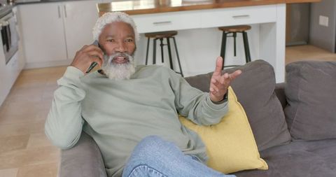 Senior Man Using Smartphone at Home Displaying Relaxed Lifestyle