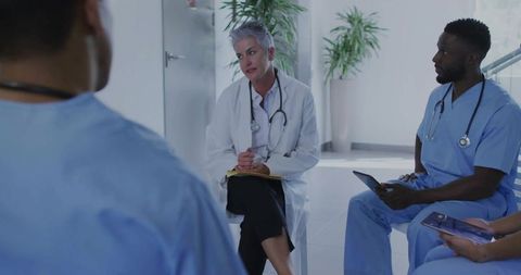 Senior doctor leading team discussion in modern hospital